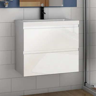 A white high-gloss bathroom vanity with two drawers is mounted on a tiled wall.