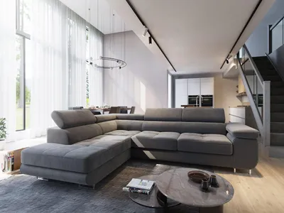 A modern living room with a large sectional sofa, dining area, and stairs leading to an upper level.