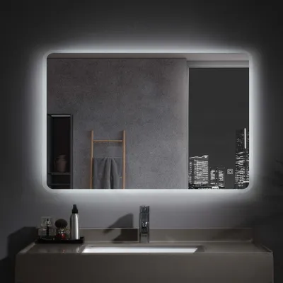 A modern bathroom vanity with a lit mirror reflecting a city skyline at night.