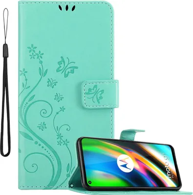 A turquoise flip case for a Motorola MOTO G9 PLUS phone, decorated with a floral and butterfly pattern. The phone is shown in a stand-up position within the case.