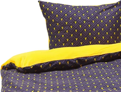 A close-up view of a bedding set, including a pillow and duvet cover, with a dark blue and yellow geometric pattern.