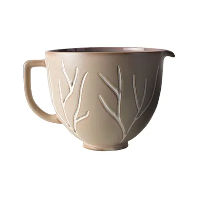A ceramic mixing bowl with a tree branch design.