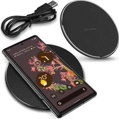 A smartphone is placed on a wireless charging pad, with a USB cable nearby.