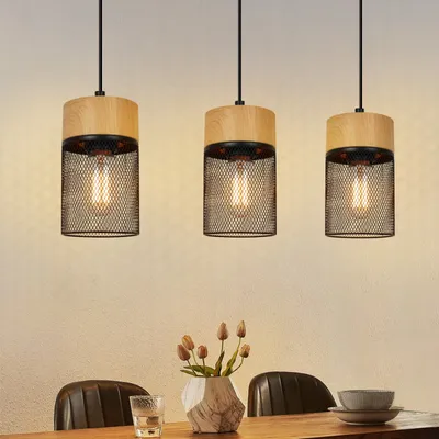 Three pendant lights hanging over a dining table.