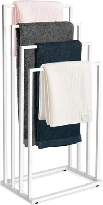A white metal towel rack with four arms, holding four folded towels of different colors: pink, gray, navy blue, and white.
