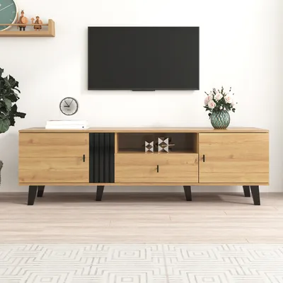 A modern TV stand with a wood grain finish and black accents is shown against a white wall.