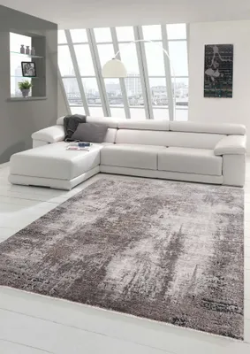 A modern living room with a large sectional sofa and a rug.
