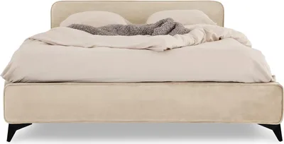 A beige upholstered bed with a duvet and pillows.