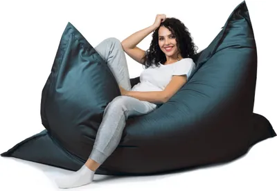A woman is sitting on a large beanbag chair.