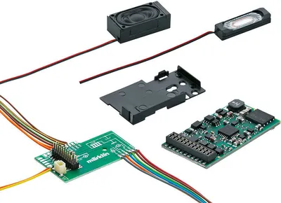 Several electronic components for a model train decoder are laid out on a white background.