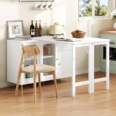 A white kitchen sideboard with a drop-leaf table extension, a chair, and kitchen items.