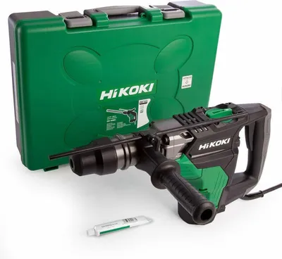 A rotary hammer drill and its carrying case are displayed on a white background, along with a small tube of lubricant.