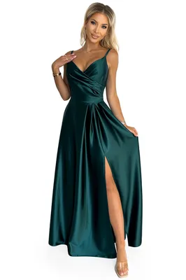 A woman wearing a long green dress with a slit.