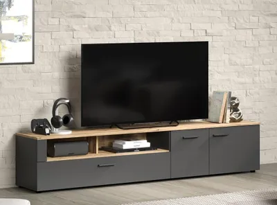 A modern TV stand with a television and accessories in a room with a brick wall.