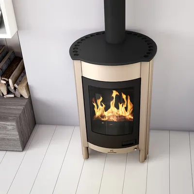 A cream-colored fireplace with a black top and flue, set against a white wall and a light gray floor. There are logs stacked to the left of the fireplace.