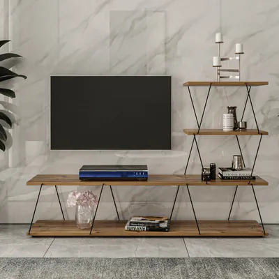 A TV stand with a TV mounted on the wall behind it, and decorative items on the shelves.