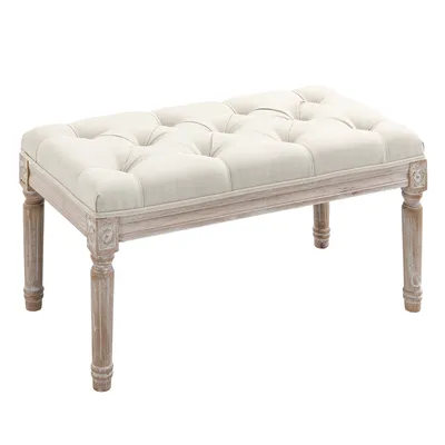 A tufted upholstered bench with carved wooden legs on a white background.