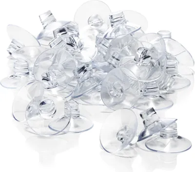 A pile of clear plastic suction cups with a small hook or slot for hanging items.