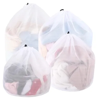 Four white mesh laundry bags filled with clothes, arranged in a group.