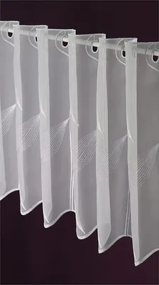 A close-up view of several white sheer curtains hanging from a rod.