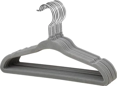 A stack of gray velvet hangers with chrome hooks.