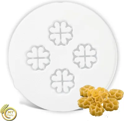 A white circular mold with clover shapes and a pile of star-shaped pasta.