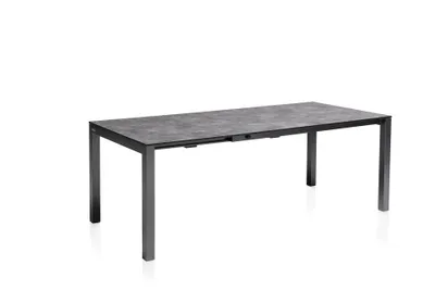 A rectangular outdoor dining table with a stone-like textured surface and dark metal legs, presented against a plain white background.