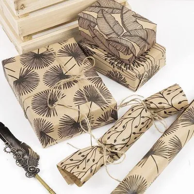 Immagine prodotto di Carta da regalo Unyqoos® in carta kraft – 4 rotoli (76 x 305 cm per rotolo), con motivo floreale stampato in nero, 4 disegni (tarassaco, foglia, fiore, bocciolo), con linea a griglia sul retro