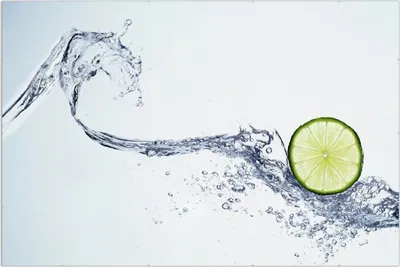 Produktbild von Wallario Wandbild Limettenscheibe in spritzigem Wasser, Größe: 61 x 91,5 cm, Poster mit rahmenlosen Bildhalter