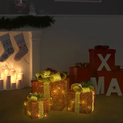 Christmas gift boxes are displayed in front of a fireplace with stockings hanging on the mantelpiece.