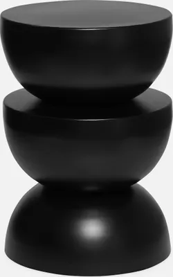 A black, hourglass-shaped side table.