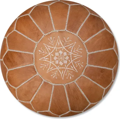 A round, brown leather pouf with white stitching and a decorative pattern in the center, presented on a white background.