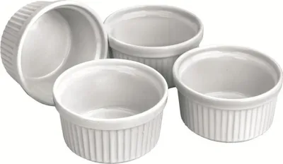 Four white ceramic ramekins are arranged on a white background.