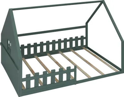 A green house-shaped bed frame with a picket fence detail and wooden slats for a mattress.