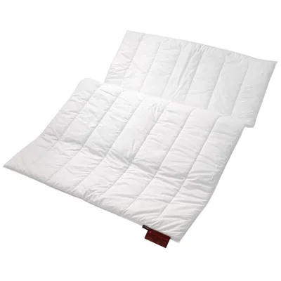 A white quilted blanket or duvet laid out on a white background.