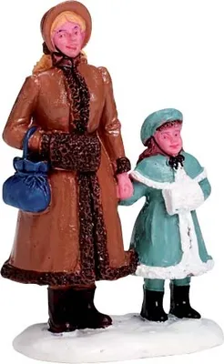 A figurine of a woman and a child dressed in winter coats, standing on a snowy base.