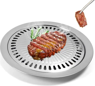 A close-up of a stainless steel grill pan with sliced steak and rosemary on it, and a piece of steak being held by tongs above.