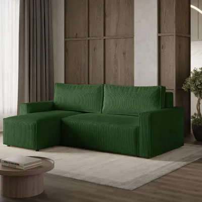 A green sectional sofa in a living room setting with a coffee table and rug.