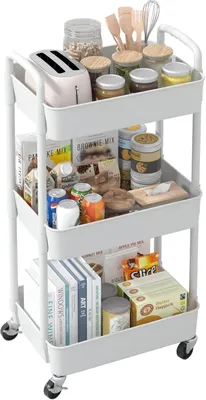 A white, three-tiered rolling cart filled with various kitchen items and some books.