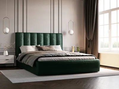A bedroom scene with a large green upholstered bed as the focal point.