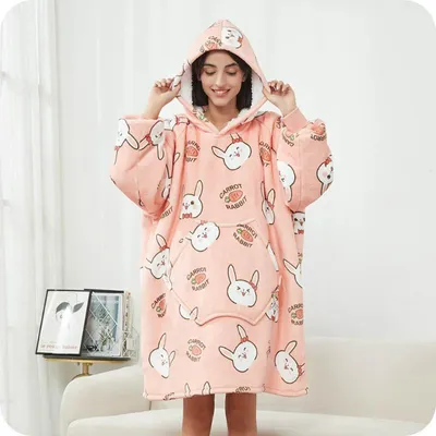 A woman wearing a pink hoodie blanket with a rabbit pattern.
