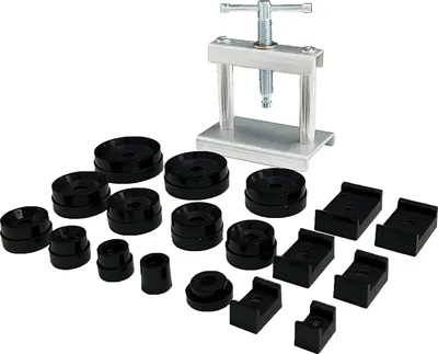A watch repair tool set with a press and various dies is laid out on a white background.
