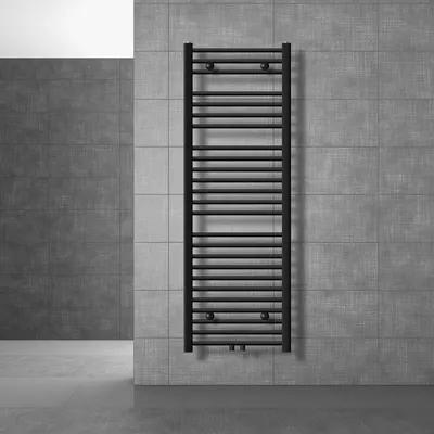 A black radiator is mounted on a tiled wall in a modern bathroom.