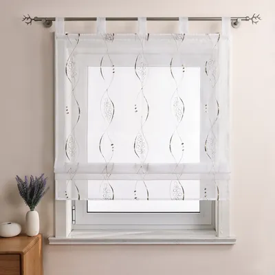 A transparent curtain with a decorative pattern hangs over a window.