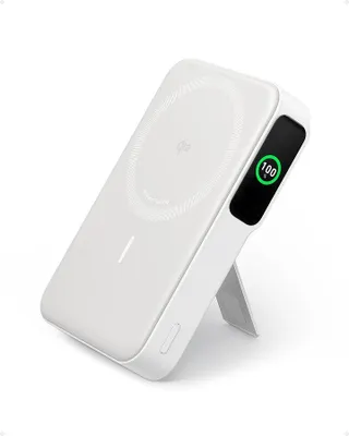 A white magnetic wireless power bank with a kickstand is shown at an angle against a white background. The power bank has a circular wireless charging pad and a small digital display showing '100%'.