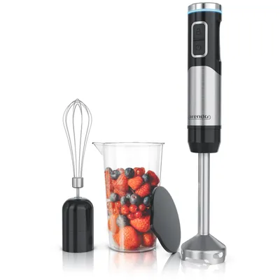 A hand blender set with a whisk attachment, a measuring cup filled with berries, and a lid, all displayed against a white background.