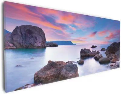 Produktbild von Wallario Premium Leinwandbild Seelandschaft in blau und rot mit großen Felsen in Größe 30 x 75 cm