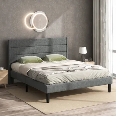 A bedroom scene featuring a bed with green pillows and a gray headboard.