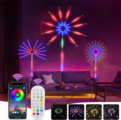 LED firework lights are displayed on a wall above a sofa in a living room, with a smartphone app and remote control shown in the foreground.