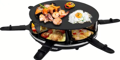 A raclette grill with food on it, presented on a white background.